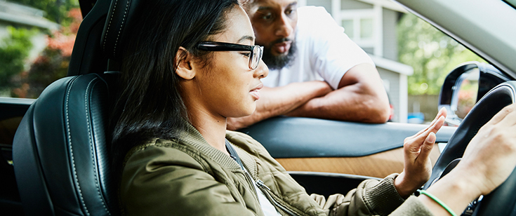 Father talking to teen while she is behind wheel of vehicle Father talking to teen while she is behind wheel of vehicle