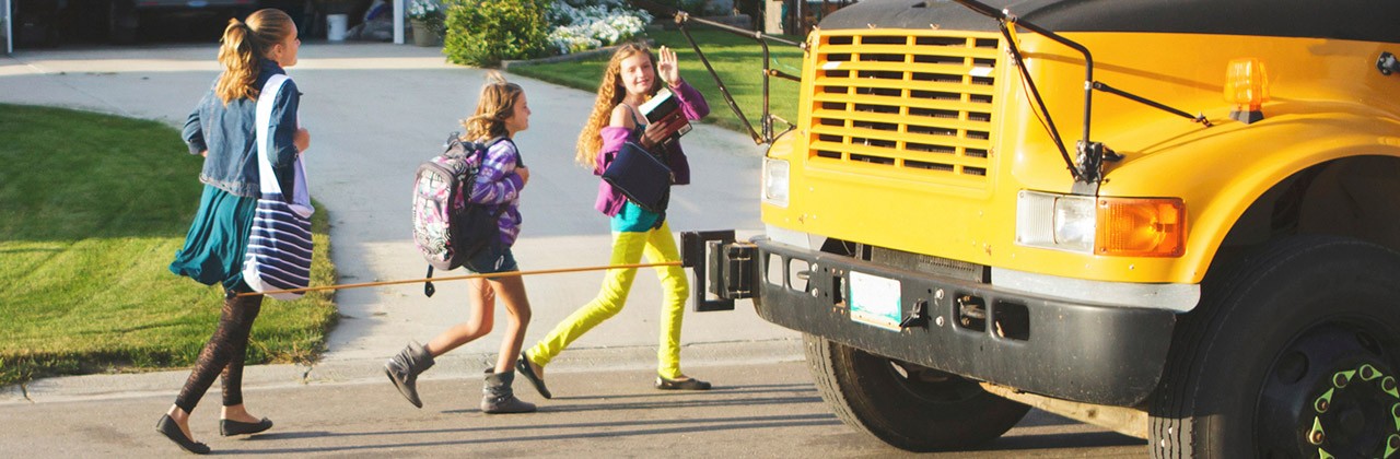 Girls walking to a school bus