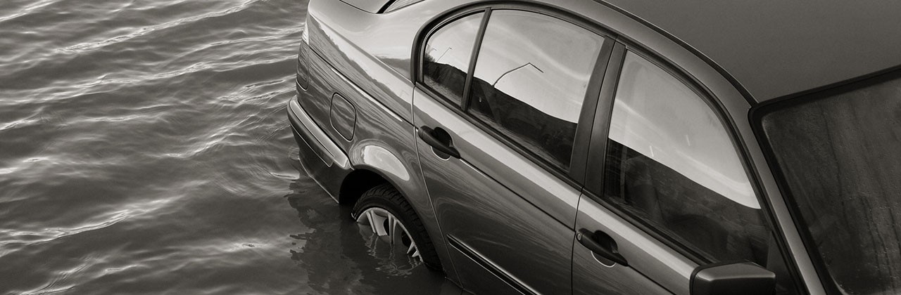 Black and white photo of a car submerged in water