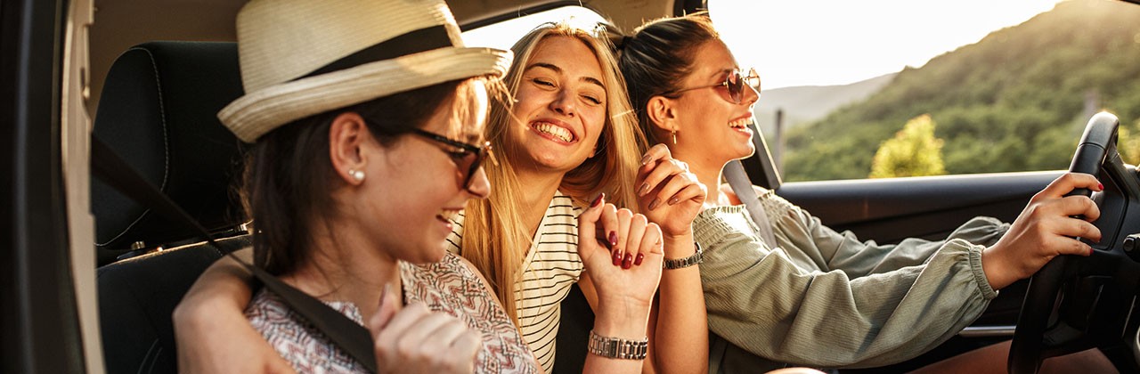 Three teenagers in a car on a summer drive