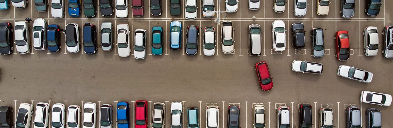 A parking lot with cars looking for a spot, seen from overhead