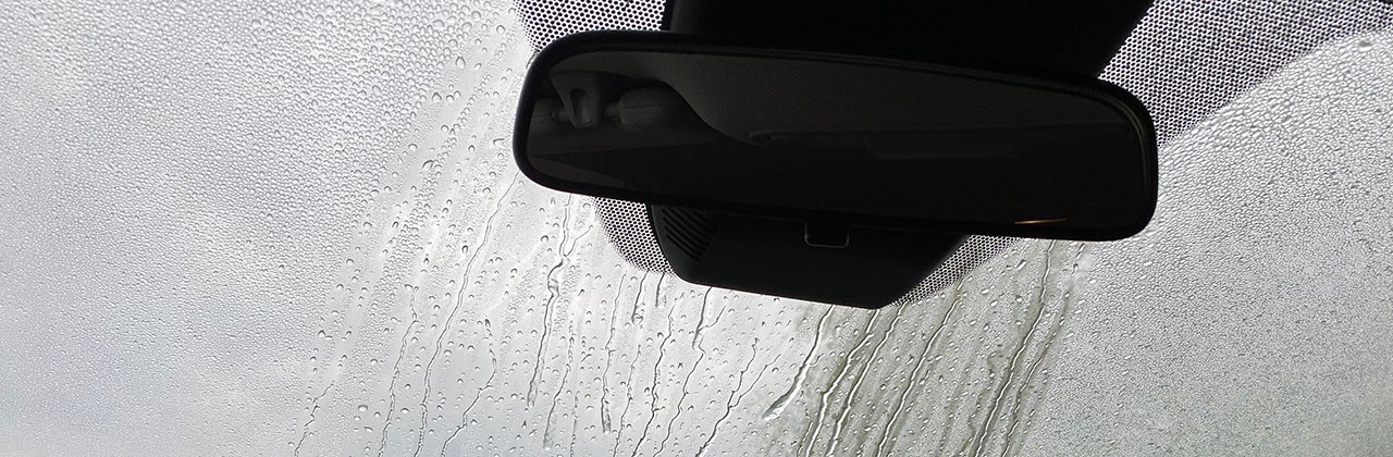 The inside of a windshield with water sprayed on it to test safety sensors