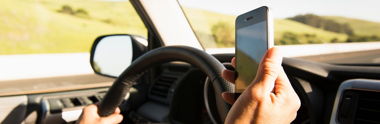 A driver looking at their phone while behind the wheel