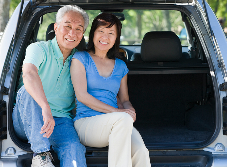 Couple sitting in back of van