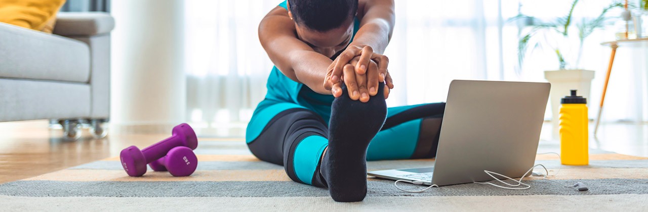 Woman doing stretches before exercising in her home