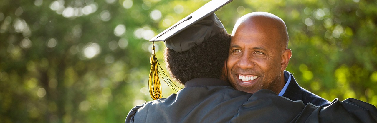 Dad son graduation hug