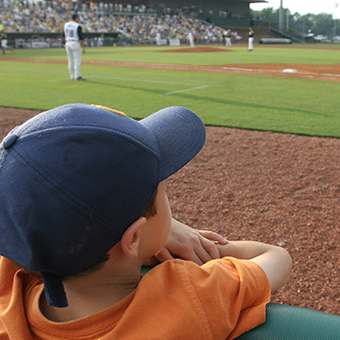 Boy watching baseball game at field level Boy watching baseball game at field level