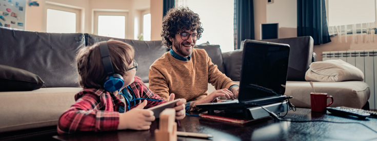 Father using laptop and talking to child Father using laptop and talking to child