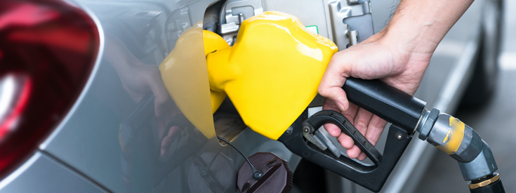 Yellow gas pump filling up vehicle