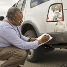 Claims adjuster looking at wrecked car