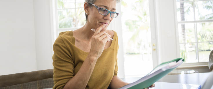 Woman reading at desk in living room