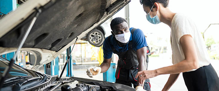 Mechanic woman masks talking auto repair shop car hood