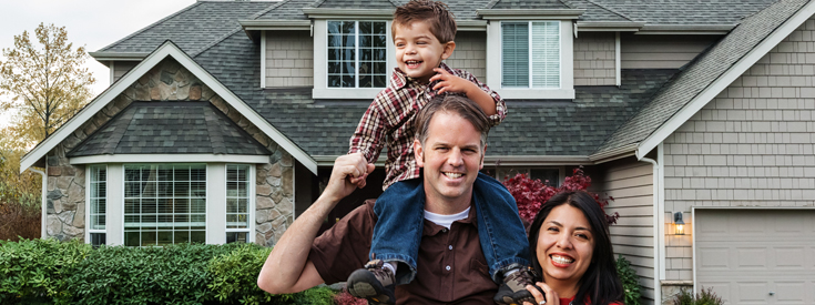 Family of three standing in front of home Family of three standing in front of home