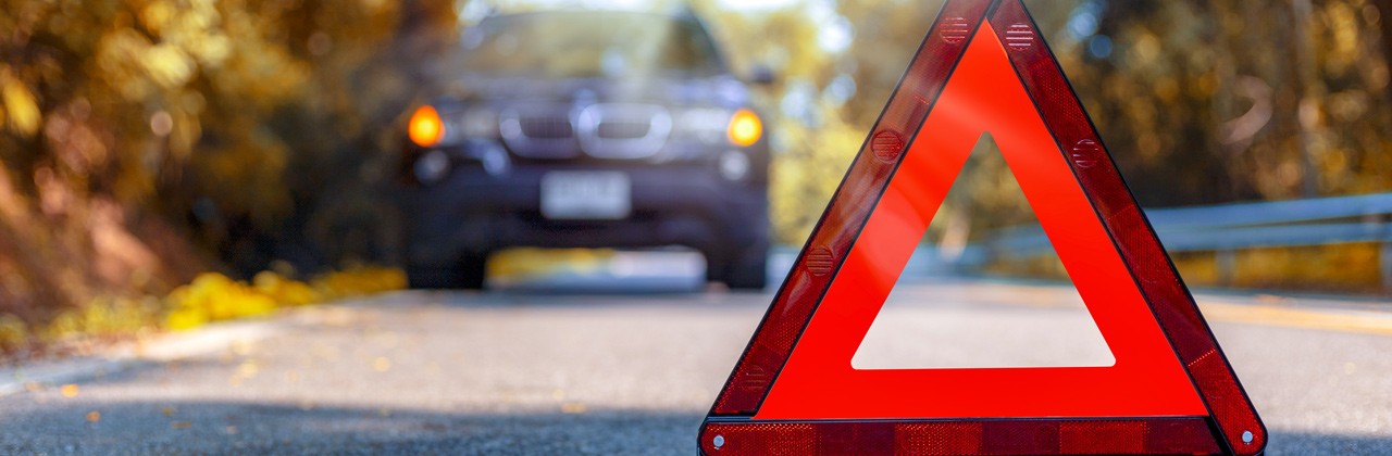 Red triangle, red emergency stop sign, red emergency symbol and black car stop and park on road.