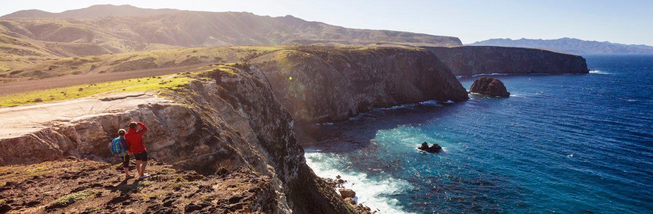 A couple looking toward the water while hiking on Santa Cruz Island