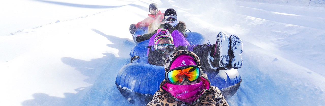 A group of 4 snow tubing at Angel Fire Resort’s Polar Coaster area