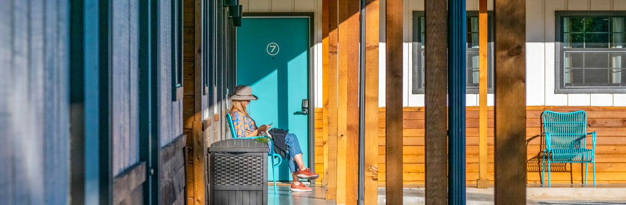 Woman sitting on a bench outside Stone Wall Motor Lodge