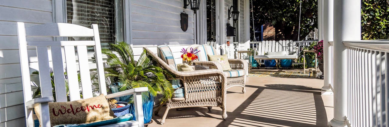 Wooden and wicker chairs on the porch at Bay Haven Inn of Cape Charles