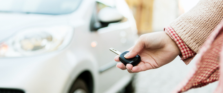 Woman with key unlocking car