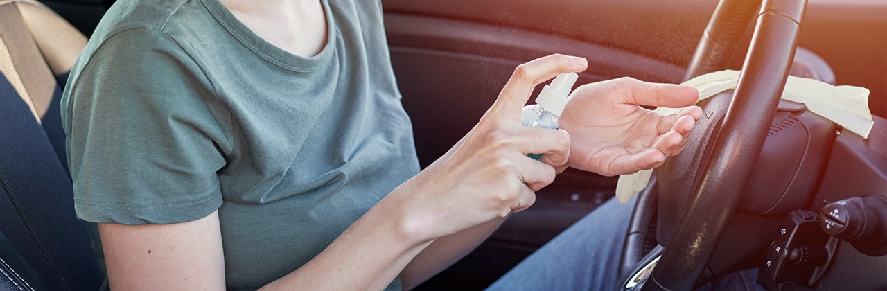 woman puts on hand santazier after getting back in the car