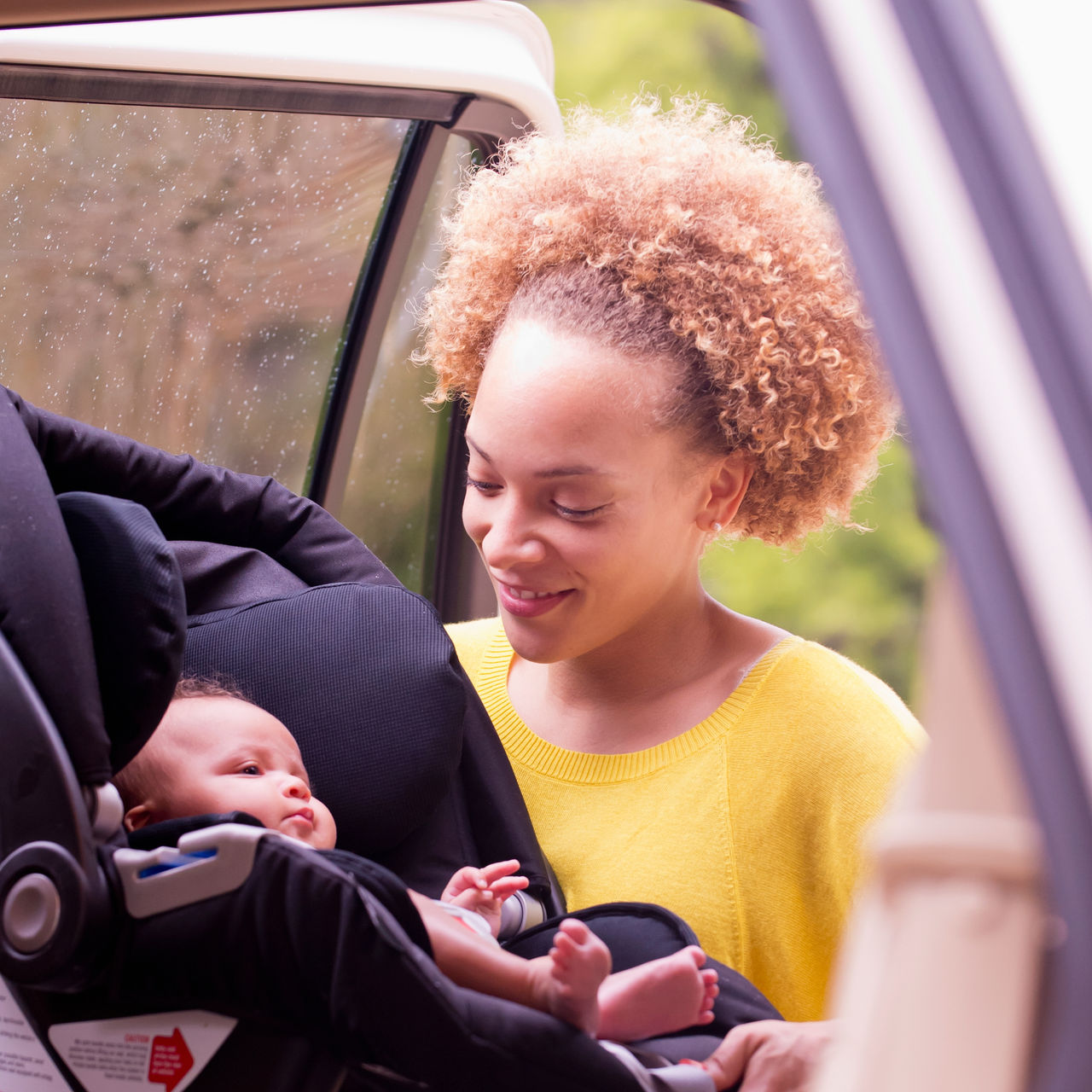 Mother loading baby into car