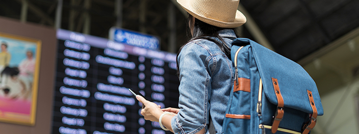 Woman at airport Woman looking at airport arrival and departure screen