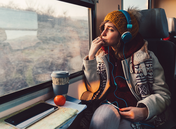 Woman on train listening to headphones
