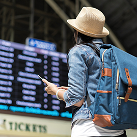 Woman at airport looking at arrival and departure screen