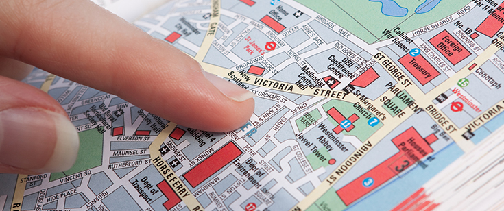 182776375-finger-pointing-tour-guide-book-map Finger pointing tour guide book map