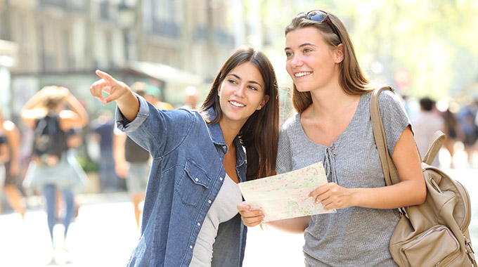 A local gives directions to a visitor holding a map