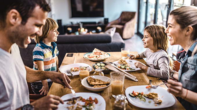 Family with two kids eating dinner at the table