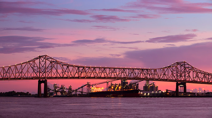 A view of the Huey P. Long Bridge over the Mississippi River at sunset