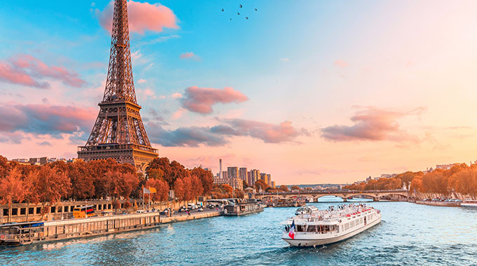 A cruise boat on the Seine in Paris at sunset, in front of the Eiffel Tower