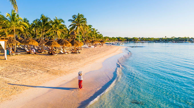 A woman walking along the sand at Playa Akumal