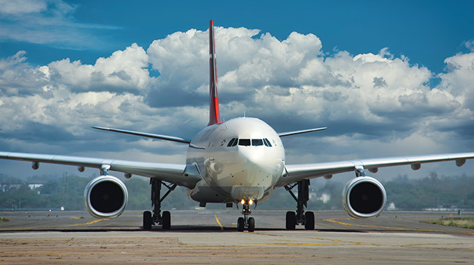 An airplane taxiing at the airport, seen from the front