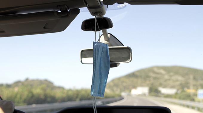 face mask hangs from car mirror