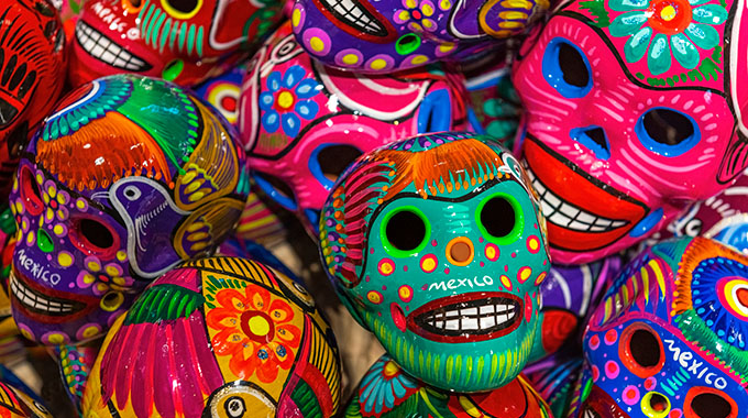 A mixture of painted ceramic calavera skulls in bright colors