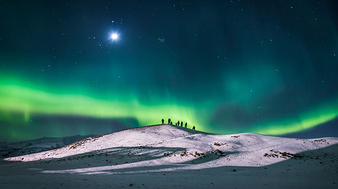 People watching the aurora borealis above Iceland