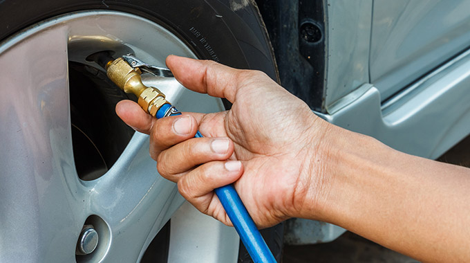 A hand putting air into a tire with an air hose