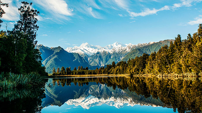 Lake Matheson in New Zealand, with snow-capped mountains in the background