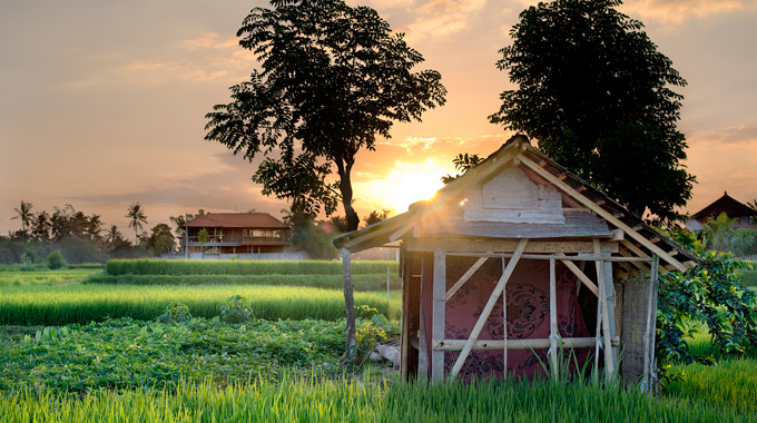 The sun sets behind a shed in Bali, Indonesia