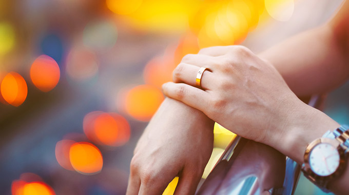 A closeup of a woman's hand with a wedding band