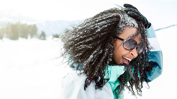 Woman smiling in cold weather with snow in her hair