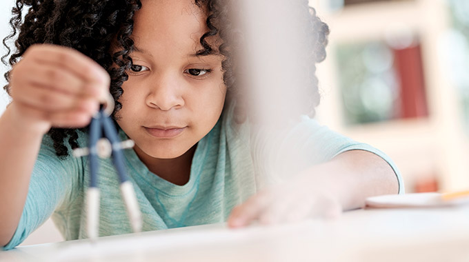 A young girl uses a compass