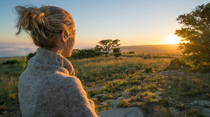 Woman looking at sunrise on the savannah in South Africa