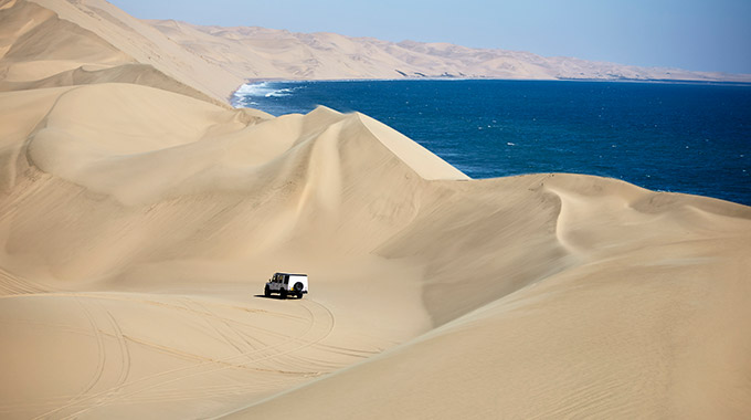 A truck crossing sand dunes in the Namib Desert on Nambia's Atlantic coast