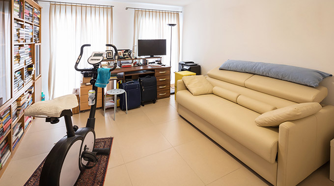 Apartment belongings including an exercise bike and couch