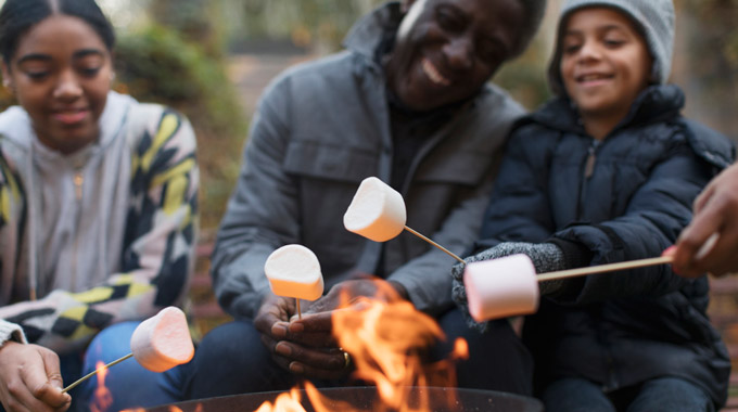 Family roasting marshmallows over a fire