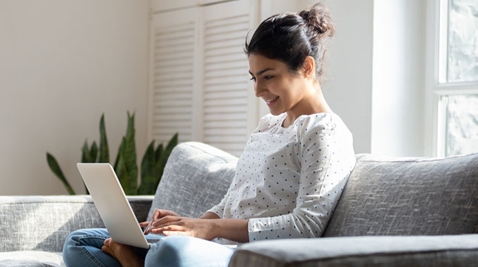 A woman filing her taxes on a laptop at home