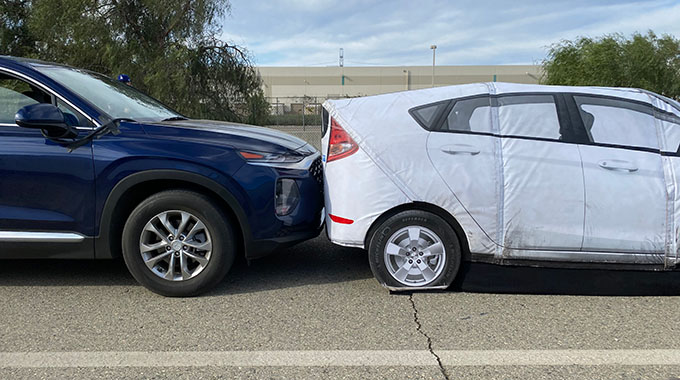 A test vehicle touching a foam target car used for testing.